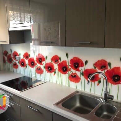 Panel szklany z motywem czerwonych kwiatów nad blatem kuchennym dodaje elegancji i subtelności, tworząc piękną dekorację, która ożywia przestrzeń kuchenną.